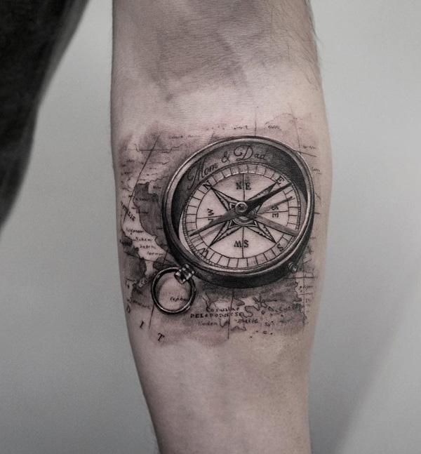 Malé černé a šedé tetování s kompasem a mapou na předloktí