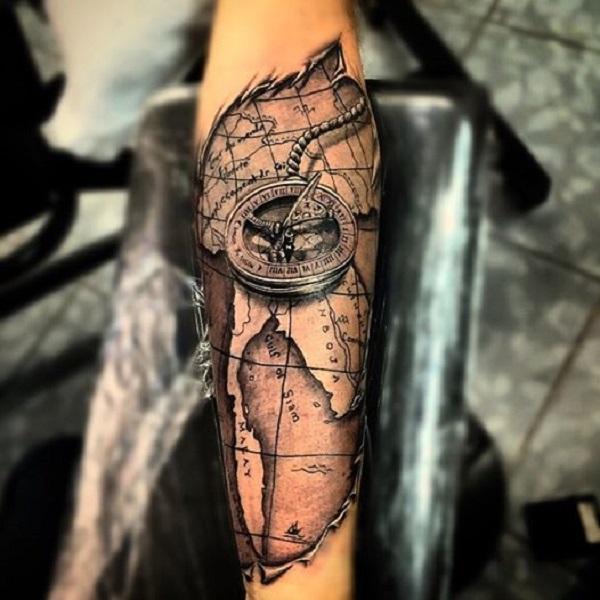 Unglaubliches schnitzendes Tattoo mit Weltkarte und nautischem Kompass am Unterarm