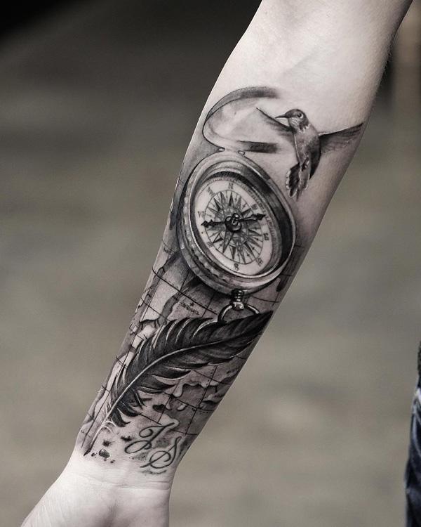 Šedé mytí tetování s námořním kompasem, peřím a kolibříkem na předloktí