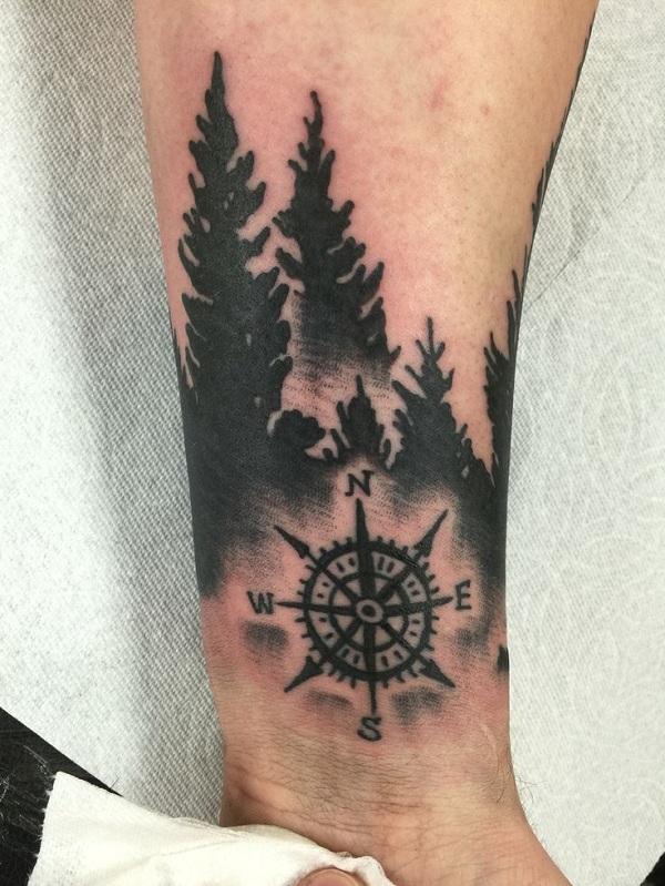 Blackwork mit Kompass und Wald am Unterarm