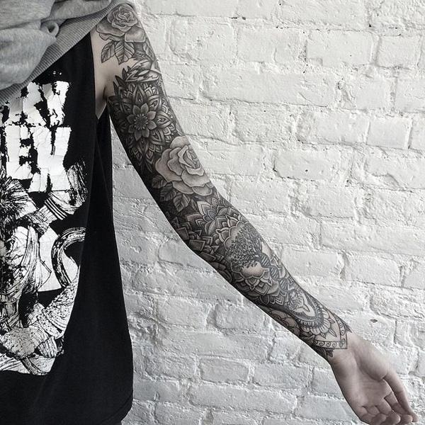 Schwarzes und graues Tattoo mit Blumen am ganzen Arm