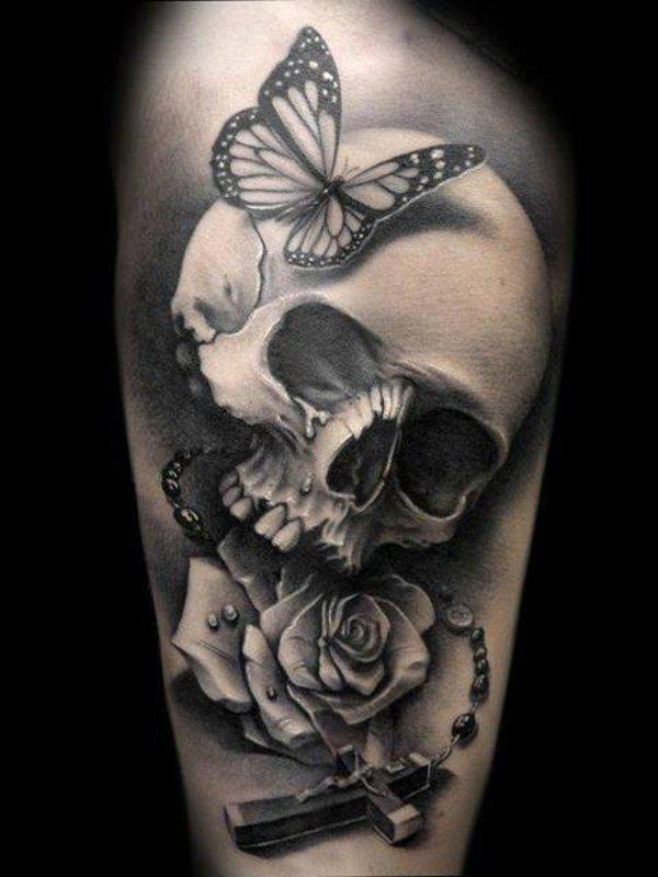 Černé a šedé tetování s lebkou, motýlem, křížem a růžencem