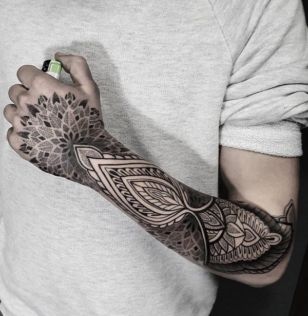 Symmetrisches Mandala inspiriertes Dotwork Tattoo, das sich vom Ellbogen bis zur Hand erstreckt