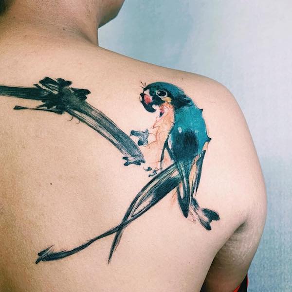 Na zádech tetování zeleného papouška
