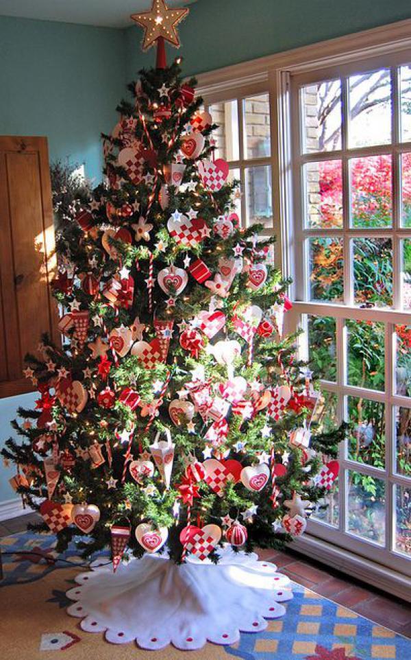 krásný vánoční strom zdobený červenými tematickými ozdobami, zmrzlinami v srdcích