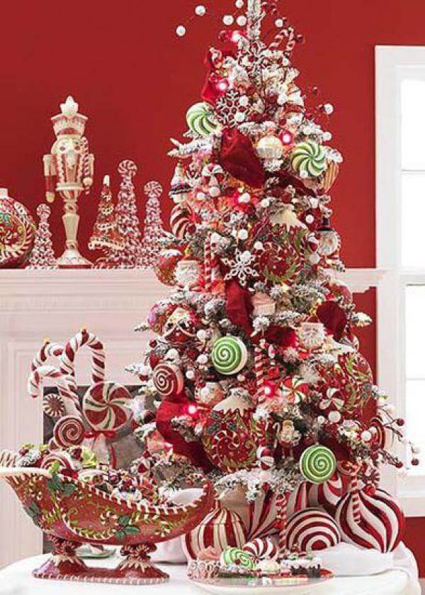 Krásné dekorativní vánoční stromeček s červenými motivy a ozdobami z cukrovinek