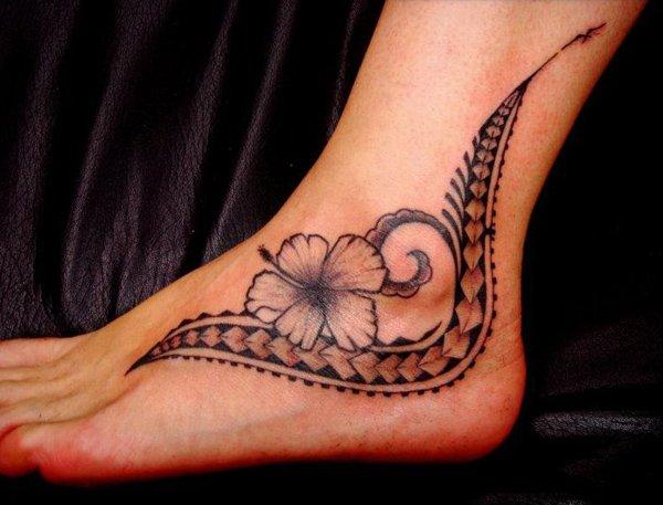 Ženské polynéské tetování inspirované stylem a prvky Samoan Tatau, květem lilie, kopími.