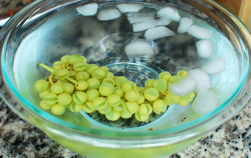 un racimo de uvas en agua fría
