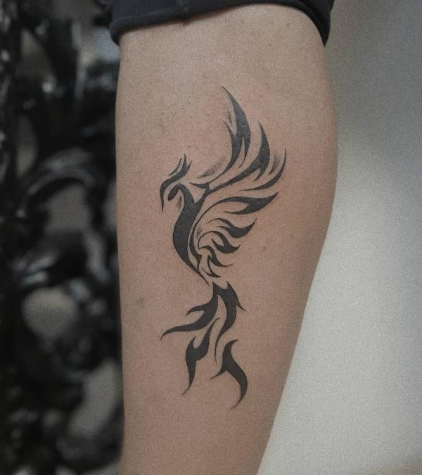 Schwarzweißes Phönix Tattoo am Unterarm im Tribal-Stil