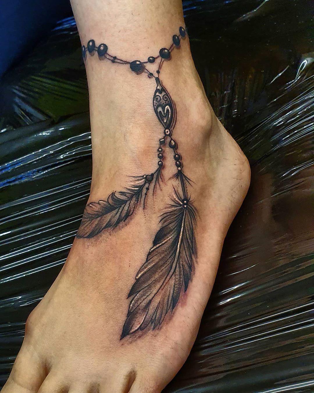 Schwarzweißes Tattoo mit Fußkettchen mit Feder im indianischen Stil