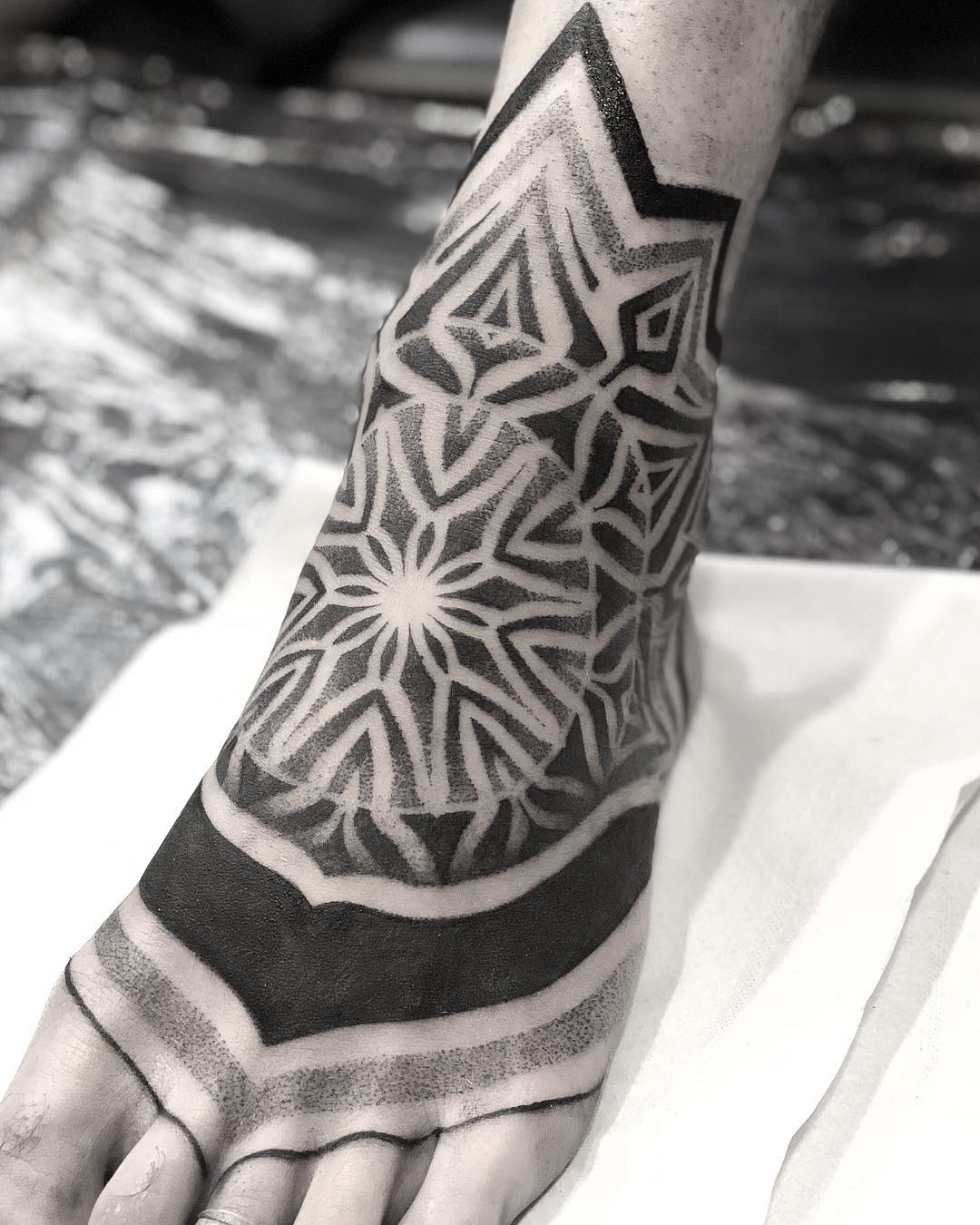 Mandala inspiriertes Fußtattoo, das wie Lager aussieht