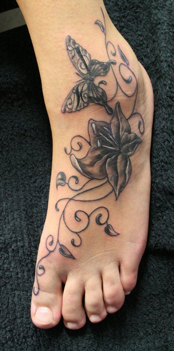 Tribal Tattoo mit Schmetterling und Blume in Graustufen