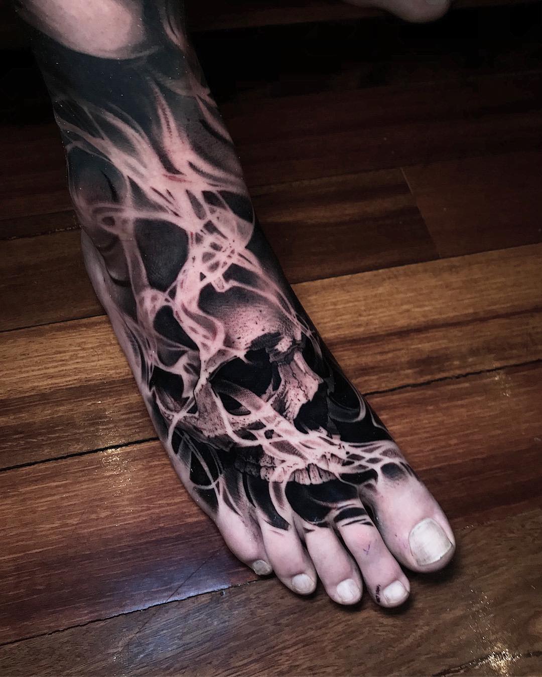 Černá a bílá noha tetování s lebkou v ohni