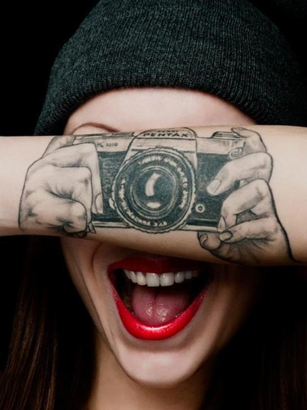 Iluzivní ruce držící tetování fotoaparátu