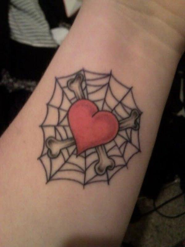 Červené srdce spojené na webu a křížové tetování