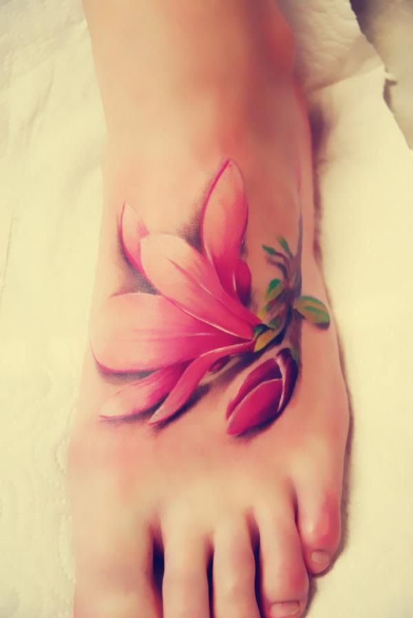 Das realistische Magnolien-Tattoo sieht aus, als würde ein Stück Blume auf den Fuß fallen