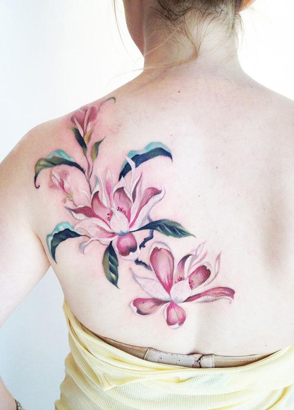 Rosa Magnolien-Blumen-Tattoo auf dem Rücken – eine feminine Tattoo-Idee für Frauen