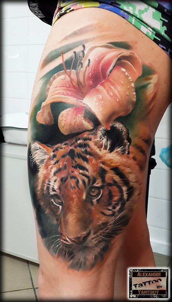 Realistické tetování lilie a tygra na noze od Alexandra Yanitského