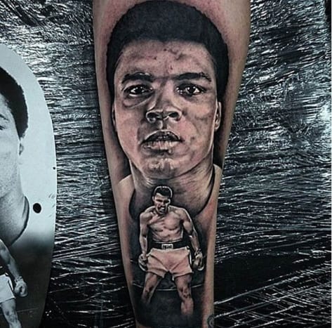 Další působivý portrét Muhammada Aliho, toto tetování paže představuje velký, detailní záběr na boxera v pozadí a menší verzi Aliho ve stejném ikonickém boji Sonnyho Listona v popředí. Černobílé tetování Muhammada Aliho provedl Kit Maxwell, tatér z Forbidden Ink ve Velké Británii, a bylo k němu jednoduše napsáno: „Legenda RIP!“