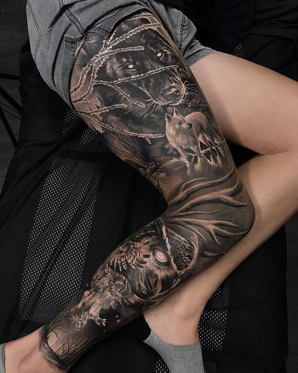 Schwarzes und graues Tier Tattoo am ganzen Bein mit Bär, Wolf und Feder