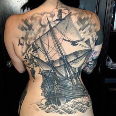 Black and Grey Pirate Ship TattooTalk o působivém zadním díle. Masivní tetování této ženy nabarvili Joshua Lord z East Side Ink NYC a Graceland Brooklyn a vyznačuje se složitým černobílým designem pirátské lodi na moři, obklopené načechranými bílými mraky a několika ptáky kroužícími kolem lodi.