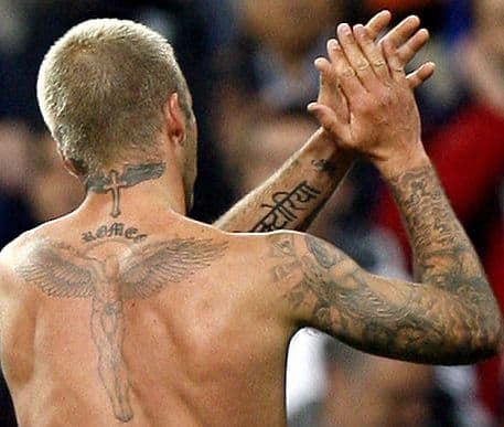 Beckham hat ein Kreuz und Flügel im Nacken. Darunter steht