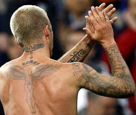 Beckham má kříž a křídla na zátylku. Pod ním se čte