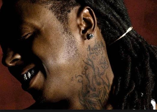 Lil Wayne ist ein weiterer Musiker, der mit einem Tattoo eine musikalische Leistung feierte, indem er das Logo von Young Money Entertainment, dem Plattenlabel, das er 2005 gründete, erhielt. Er hat auch die Worte Sqad auf seine Fingerknöchel tätowiert, was für den Hip-Hop steht Gruppe Sqad Up, die seine erfolgreiche Rap-Karriere startete.