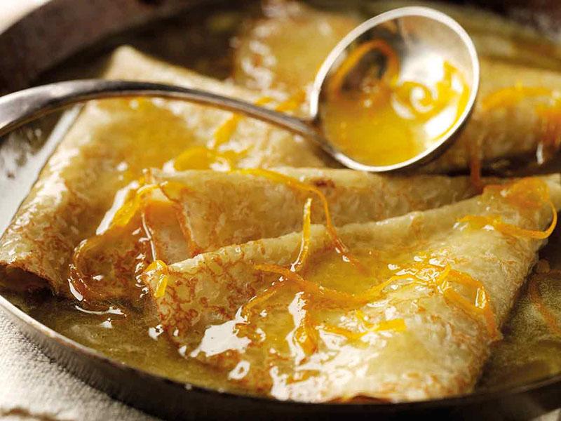 verser les crêpes à la sauce à l'orange