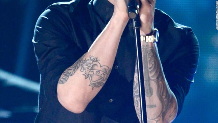 A Lovato není jedinou celebritou, která toto pravidlo tetování porušuje. Podívejte se na maminku Adama Levina tetování - které, když má paži sklopené, říká „Páni.“
