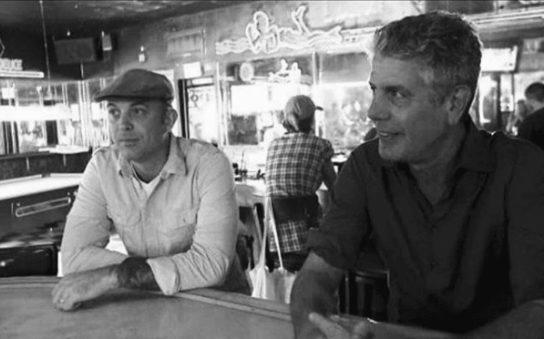 Abgesehen von dem Tätowieren von Evel Kneivel (meinem Kindheitshelden) war Anthony Bourdain einer meiner Lieblings-Promi-Kunden. Ich traf ihn 2005 beim Sundance Film Festival und wir waren die einzigen Raucher aus dem Discovery Channel-Kontingent, also hingen wir ziemlich viel rum. Er kam mir als wirklich echter und nachdenklicher Typ vor und wir haben viel gelacht. Ich reise wirklich gerne und mache keine touristischen Sachen, wie er es offensichtlich getan hat, also hatten wir einige großartige Gespräche. Ich habe ihn zuerst mit einem Totenkopf tätowiert und dann im Laufe der Jahre einige andere kleine Dinge. Ich erinnere mich, dass ich ihm gesagt habe, er solle anfangen, größere Sachen zu bekommen, damit er nicht wie ein Dampferkoffer mit Aufklebern aussieht. (was ihm eigentlich passen würde). Als ich von seinem Tod hörte, hat es mich wirklich erschüttert und ich denke immer noch die ganze Zeit daran zurück. Er kam vor kurzem, um sich in meinem Geschäft tätowieren zu lassen und er schien wirklich glücklich zu sein, also hat es mich total überrascht. Er war jemand, den ich wirklich bewunderte, jemand, der ein aufregendes und erfülltes Leben zu führen schien. Es macht für mich immer noch keinen Sinn. Wie so viele andere werde ich ihn sehr vermissen.