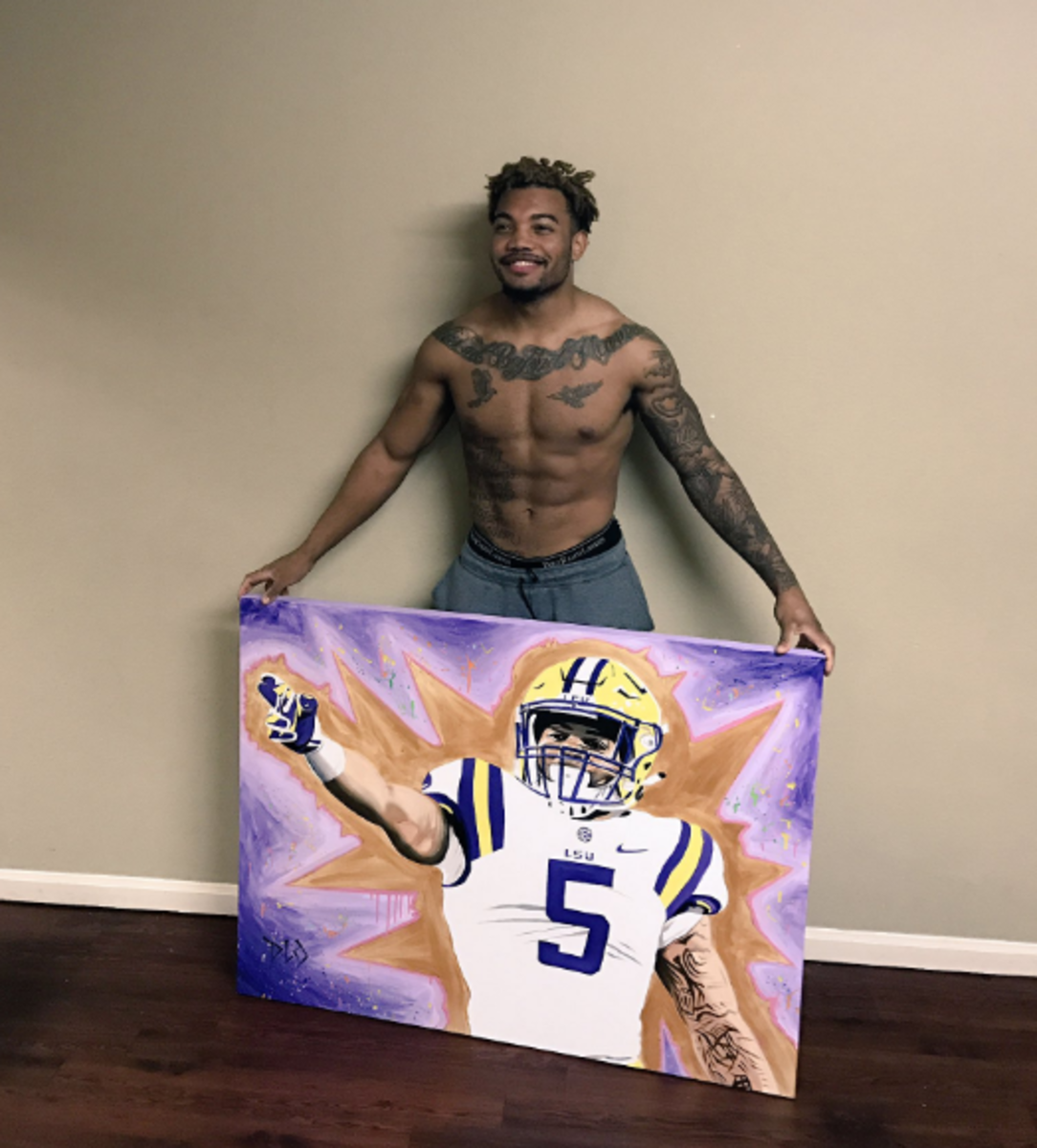 Derrius Guice hält ein Gemälde von sich in seiner LSU-Uniform hoch. Foto: Twitter.