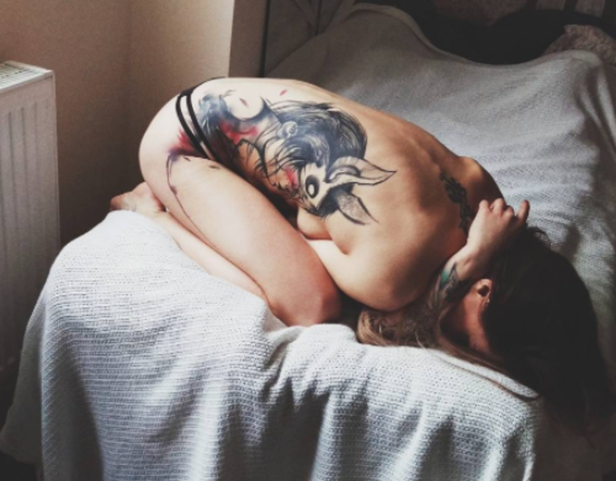 Mädchen auf dem Bett mit Seitenteil Tattoo