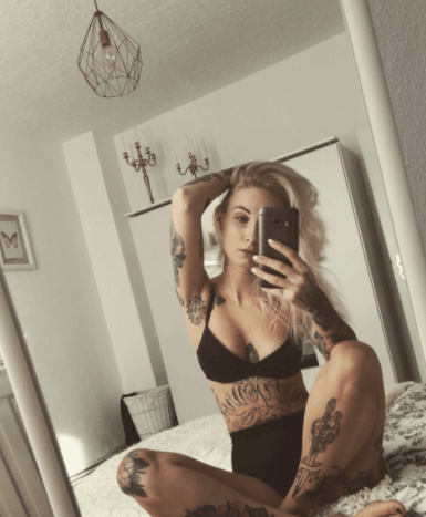 Tattoo Mädchen auf dem Bett Selfie