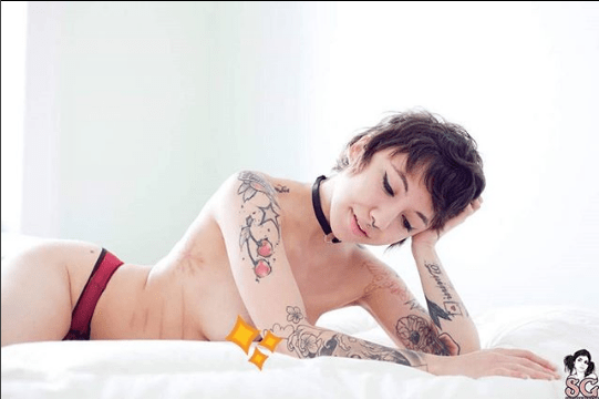 Fotografie z Alderaanovy stránky SuicideGirl Stránka skarifikační štěrbiny na jejím boku rámuje její tělo.