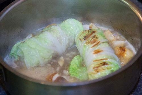 poner rollos de repollo rellenos en salsa y hervir a fuego lento