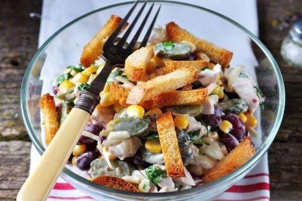 ensalada con frijoles y picatostes, y maíz