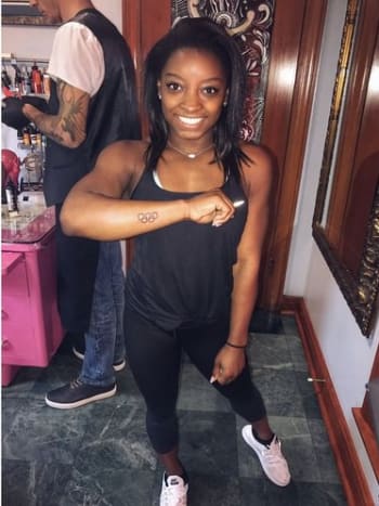 Simone Biles zeigt ihr frisches Tattoo mit den Olympischen Ringen. Foto: Simone Biles/Instagram. Die Medaillengewinnerin teilte auch ein Foto ihres neuen Tattoos auf ihrem eigenen Instagram-Account, auf dem die Ringe auf der Außenseite ihres rechten Unterarms in der Nähe ihres Handgelenks zu sehen sind.