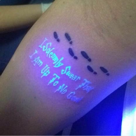 Dieses Tattoo mit Harry-Potter-Thema zeigt drei Sätze von Fußabdrücken, die horizontal über den Arm eingefärbt sind, aber ein Schwarzlicht enthüllt den Rest der Tinte, der den Satz enthält: 
