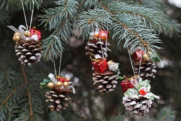 décorer le sapin de Noël avec des jouets en forme de pomme de pin