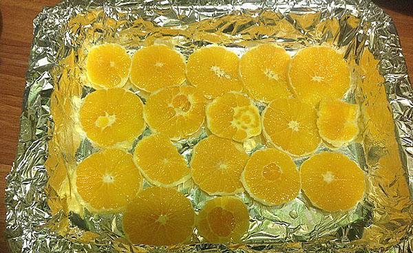 poner las naranjas en rodajas en una bandeja para hornear