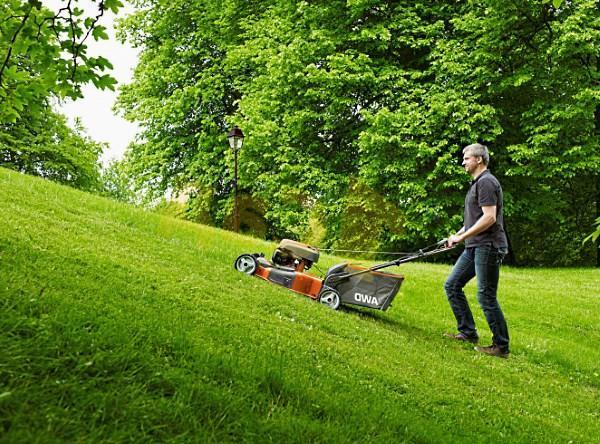 un homme avec une tondeuse à essence