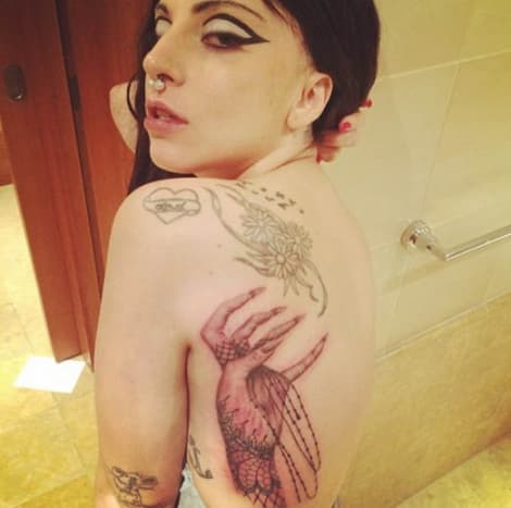 Jeden z jejích nejnovějších kousků a to, co Gaga označuje jako „tlapku příšer“, sahá na ni ze zad.