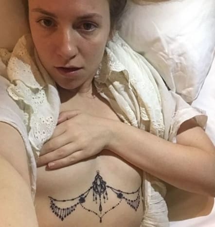 (Foto: Lena Dunham/Instagram)Dunhams neuestes Tattoo sieht aus wie ein Stück dauerhaften Körperschmucks, mit einem verzierten, raspelartigen Stück, das in der Mitte ihrer Brust verankert ist, und einer perlenbesetzten Zierkette, die sich unter jeder ihrer Brüste erstreckt. Dunham debütierte ihr neues Brusttattoo auf Instagram und betitelte das Selfie ohne Hemd: 