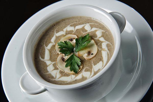 servir la soupe avec de la crème sure et des herbes