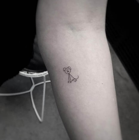 Stick Figure Dog TattooNemusíte si nechat udělat velké tetování do obličeje. Svou lásku ke zvířatům můžete stále projevovat jednoduchým, diskrétním kouskem, jako je toto drobné tetování pejska. Minimalistický tat, provedený tetovacím umělcem Balazsem Bercsenyim z NYC, je asi tak jednoduchý, jak jen jde, ale přesto je tak roztomilý, jak jen může být!