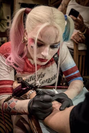 Její svatební den samozřejmě není poprvé, kdy Margot Robbie tetovala své přátele. Dala několik svých tetování „SKWAD“, aby si připomněla jejich společný čas při natáčení letního filmu Suicide Squad v roce 2016, a také přibližně ve stejnou dobu namalovala spoustu tetování smajlíků emoji na prsty Cara Delevingne. Robbie je první, kdo přiznal, že není nejlepší v tetování-své návrhy přirovnává k tomu, „co by 4leté dítě nakreslilo a nalepilo na vaši ledničku“-ale to jí nezabránilo natírat své svatební hosty!