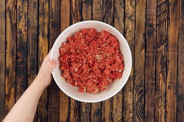 mélanger la viande hachée avec les oignons et les épices
