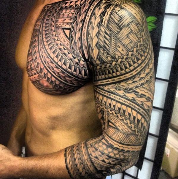 Polynéské tetování na hrudi a rukávu s kopími a copánky