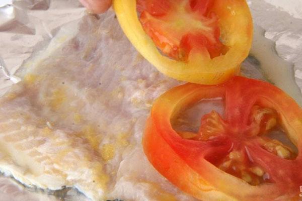 poner cebollas y tomates en el pescado